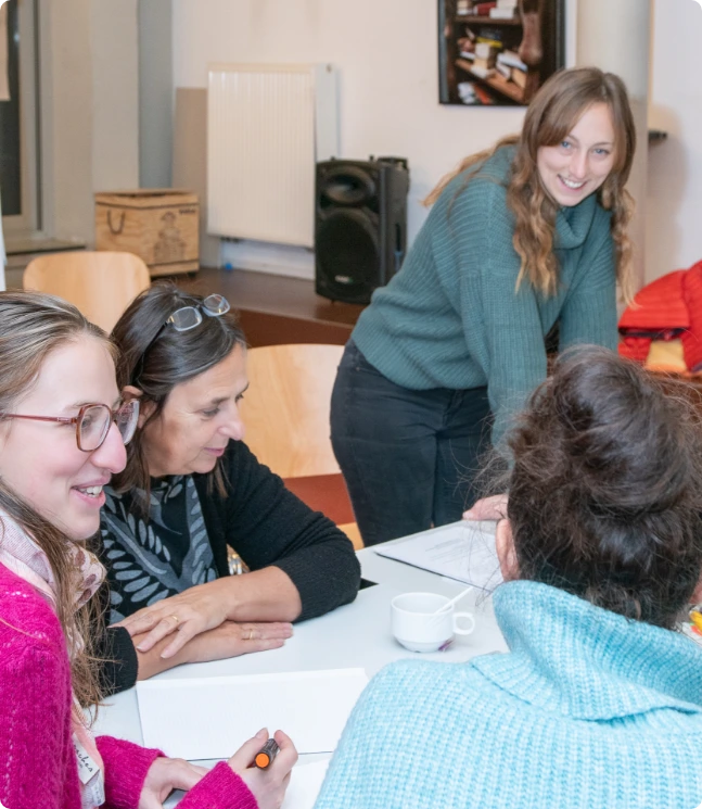 Une photo d’Adeline Heymans, facilitatrice en intelligence collective, formatrice et organisatrice d’événements, avec 3 participantes d’un atelier découverte des outils d’intelligence collective, à la Maison des Femmes de Schaerbeek. oplic asbl à Bruxelles Belgique